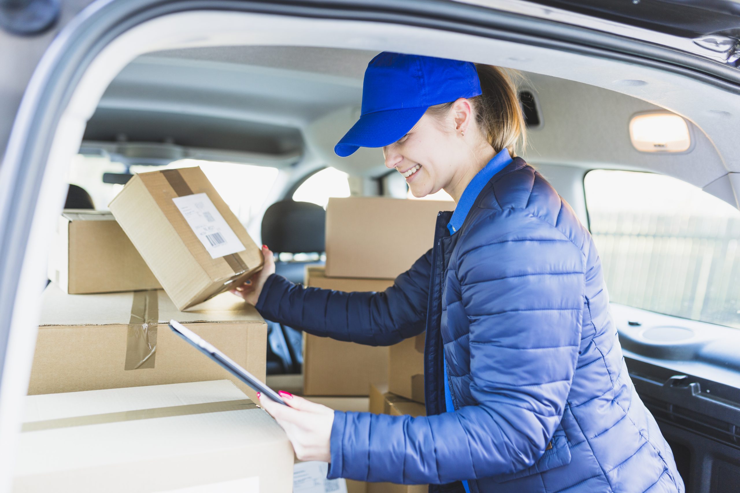 Chica con tableta y cajas en coche 2
